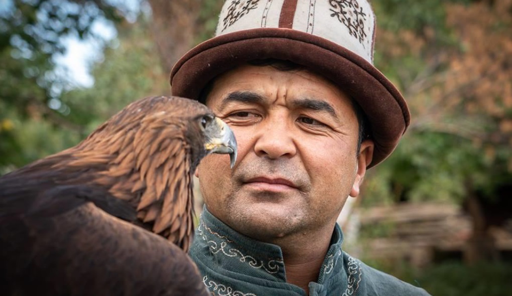 יליד קירגיזסטן מחזיק ציפור על הכתף